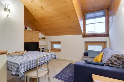 a living room with a blue couch and a table at Apartments Trettel in Tesero