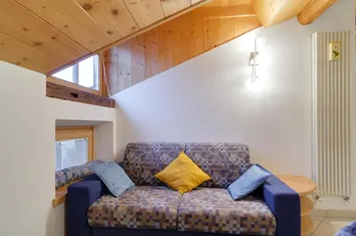a living room with a couch with a yellow pillow at Apartments Trettel in Tesero