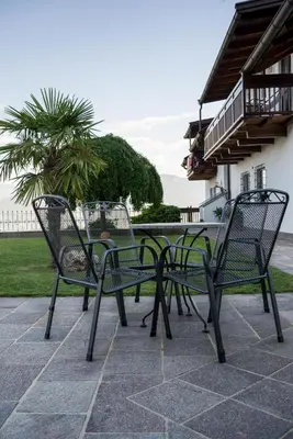 three chairs and a table on a patio at Strahlerhof in Appiano sulla Strada del Vino