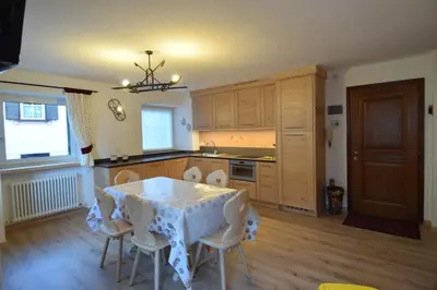 a kitchen with a table and chairs in a room at Vajolet in Campitello di Fassa