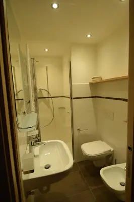 a bathroom with a sink and a toilet and a mirror at Vajolet in Campitello di Fassa