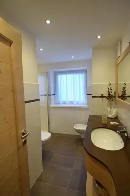 a bathroom with a sink and a toilet and a window at Vajolet in Campitello di Fassa