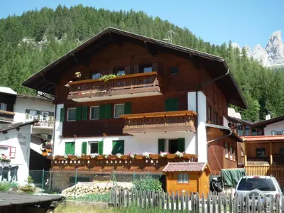 a building with balconies and a fence in front of it at Vajolet in Campitello di Fassa