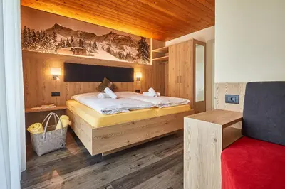 a bedroom with a bed with a painting on the wall at Alpin Relais B&B Villa Melisse in Colfosco