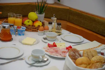 a table topped with plates of food and fruit at Haus Sonnegg in Marlengo