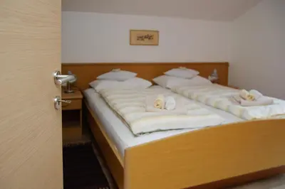 two beds in a room with towels on them at Haus Sonnegg in Marlengo