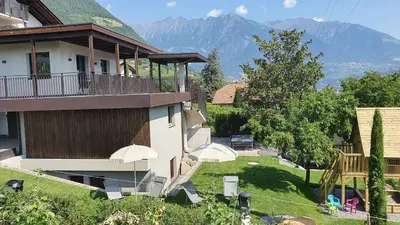 a house with a balcony with a view of a yard at Haus Sonnegg in Marlengo