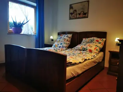 a bed with a wooden headboard in a bedroom at Dolomiti Di Brenta in Ronzone