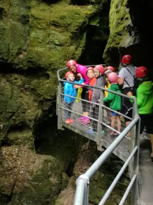 a group of people on a bridge in a cave at Dolomiti Di Brenta in Ronzone