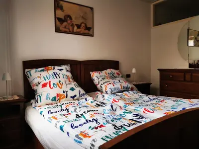 a bed with a happy birthday quilt and two pillows at Dolomiti Di Brenta in Ronzone