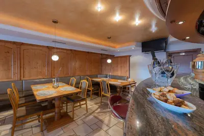 a kitchen with wooden cabinets and a table and chairs at Cristallo B&B in Castelrotto
