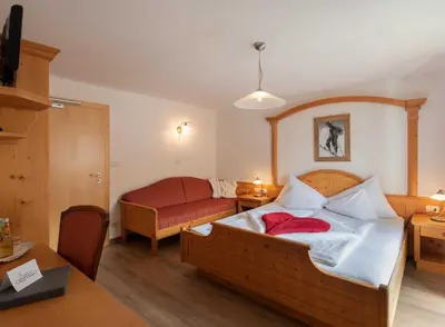 a small bedroom with a bed and a couch at Cristallo B&B in Castelrotto