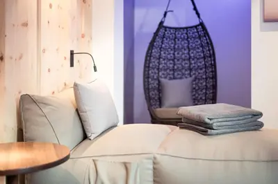 a living room with a couch and a chair at Hotel Berghang in Collepietra