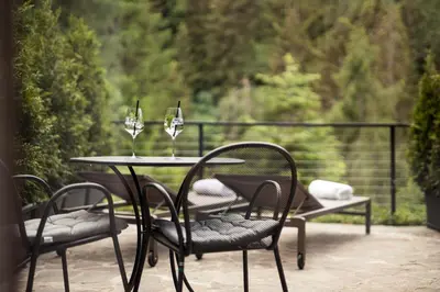 a table and chairs with wine glasses on a patio at Hotel Berghang in Collepietra