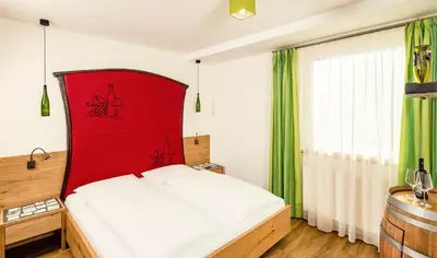 a bed with a red headboard in a room at Gasthof Hotel Terzer in Cortaccia