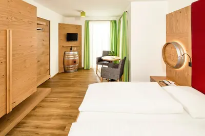 a hotel room with a bed and a table at Gasthof Hotel Terzer in Cortaccia