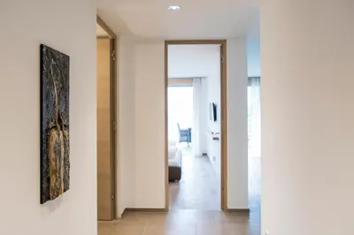 a hallway of a house with white walls and wooden floors at Art & Nature Chalet Anna in Schenna
