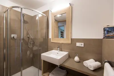a bathroom with a sink and a shower at Art & Nature Chalet Anna in Schenna