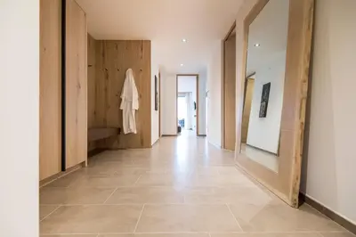 a hallway with wooden doors and a tile floor at Art & Nature Chalet Anna in Schenna
