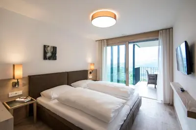 a bedroom with a large bed and a large window at Art & Nature Chalet Anna in Schenna