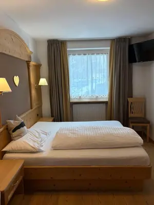 a bedroom with a large bed with a window at B&B MARINA contacless check in in Santa Cristina in Val Gardena