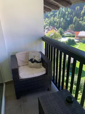 a wicker chair with a pillow on a balcony at B&B MARINA contacless check in in Santa Cristina in Val Gardena