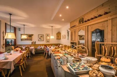 a restaurant with tables with food on them at Garni Raetia in Corvara in Badia