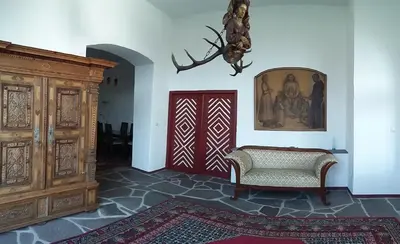 a living room with a door and a chair and a rug at Brandlgut in Bolzano