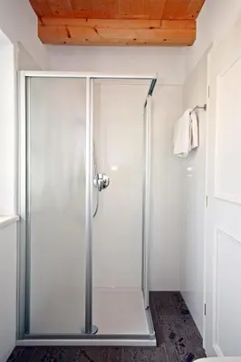 a shower with a glass door in a bathroom at Brandlgut in Bolzano
