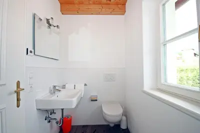a white bathroom with a sink and a toilet at Brandlgut in Bolzano