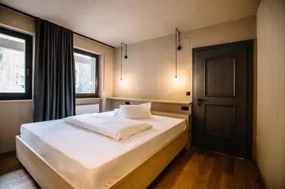 a bedroom with a bed and a window and a door at Panoramic Suites Winzerhöhe in Schenna