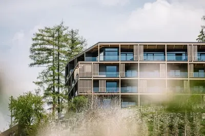 an apartment building with trees in front of it at Panoramic Suites Winzerhöhe in Schenna