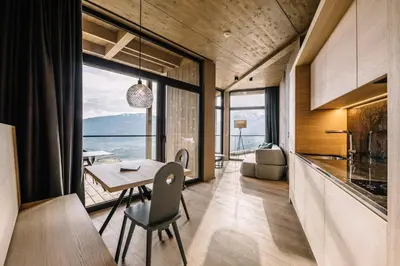 a dining room with a table and a view of the ocean at Panoramic Suites Winzerhöhe in Schenna