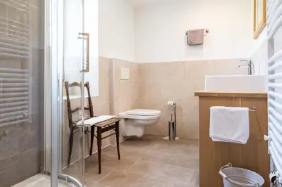 a bathroom with a toilet and a sink and a shower at Villa Alba in La Villa