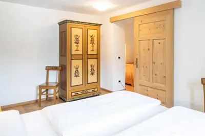 a bedroom with two beds and a wooden cabinet at Villa Alba in La Villa