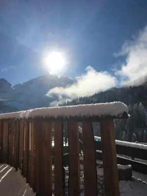 a snow covered railing with the sun in the sky at Villa Alba in La Villa