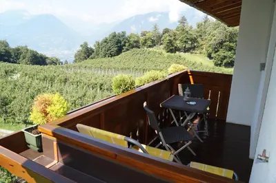 a balcony of a house with a table and chairs at Grumserhof in Merano