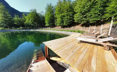 a wooden dock with benches on top of a lake at Grumserhof in Merano