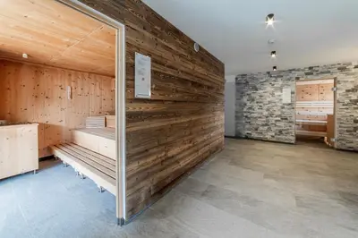 a room with a wooden wall with benches in it at B&B Boutique Apartment Oberwiesen in Brunico