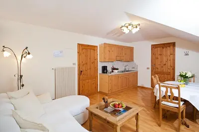 a living room with a white couch and a table at Residence Fischerhof in Tirolo