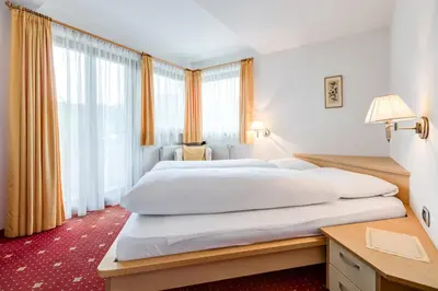 a bedroom with two beds and a desk at Pension Haus am See in Naz-Sciaves