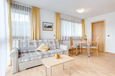 a living room with a couch and a table at Pension Haus am See in Naz-Sciaves