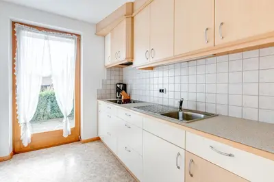 a kitchen with a sink and a window at Pension Haus am See in Naz-Sciaves