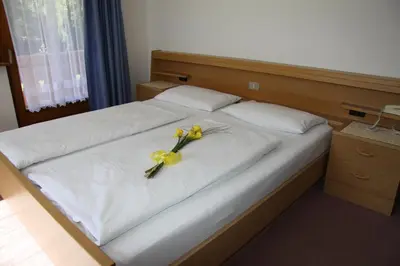 a bed with two yellow flowers on top of it at Garnì La Grambla in Selva di Val Gardena