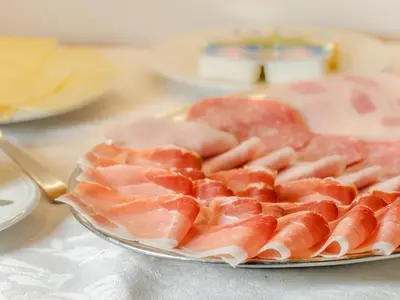 a plate of meat on top of a table at Garnì La Grambla in Selva di Val Gardena