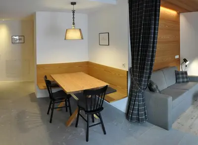 a living room with a wooden table and a couch at Apartments Frieda in Valdaora
