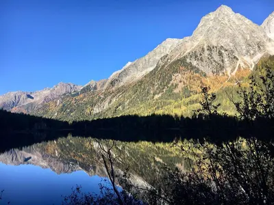 a view of a mountain reflecting in a lake at Apartments Frieda in Valdaora