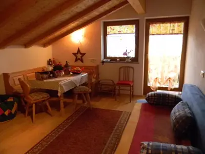 a living room with a table and chairs and two windows at Unterweger Hof in Avelengo