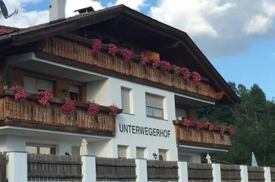 a building with a balcony with flowers on it at Unterweger Hof in Avelengo