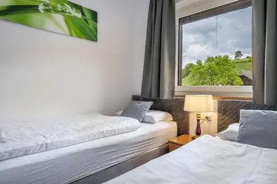 two beds in a room with a window at Apartments Woerndle in Siusi